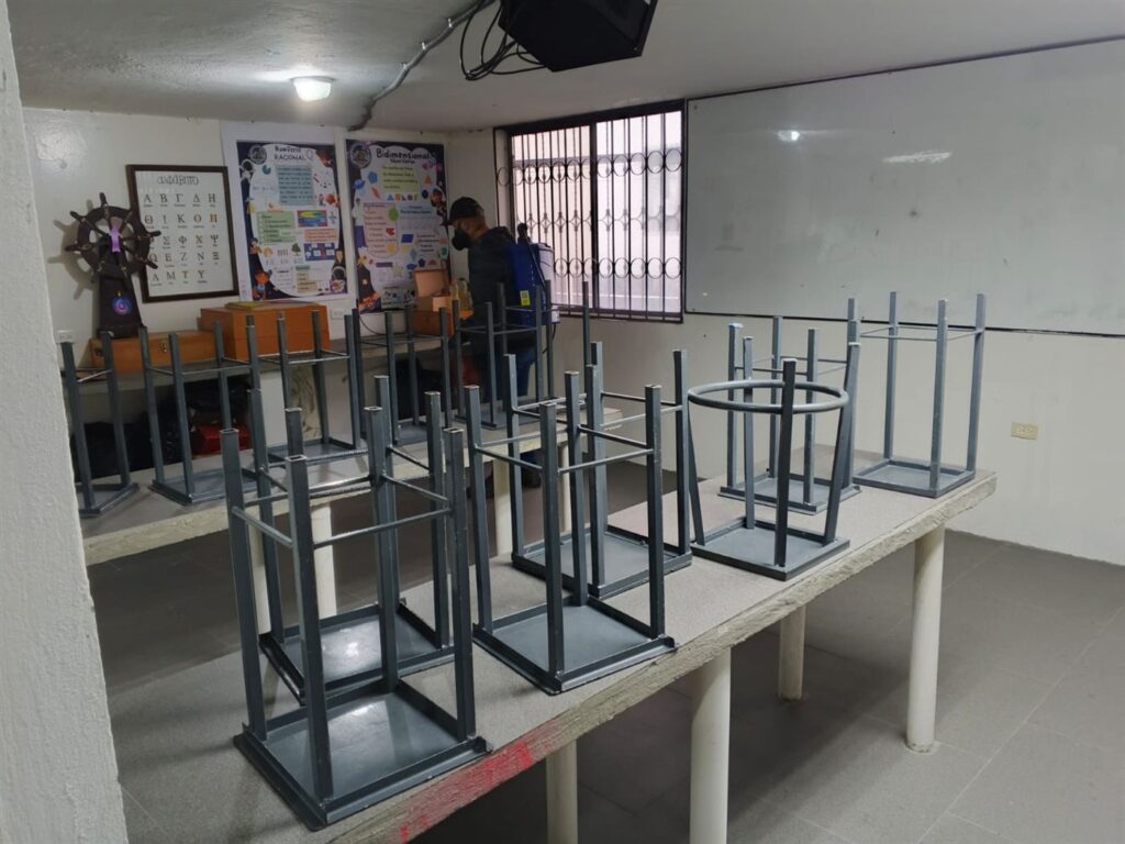 Técnico aplicando control de plagas en laboratorio de cómputo en Quito